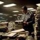 Businessman Sorting Through Massive Paperwork in Office