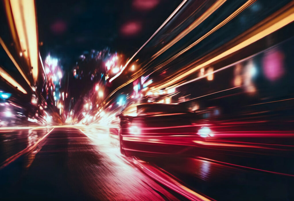 A dynamic image of a street at night showing light trails