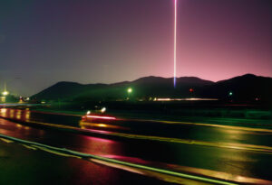 Nighttime Highway Beneath Cosmic Beacon, A Long Exposure of Movement and Mystery